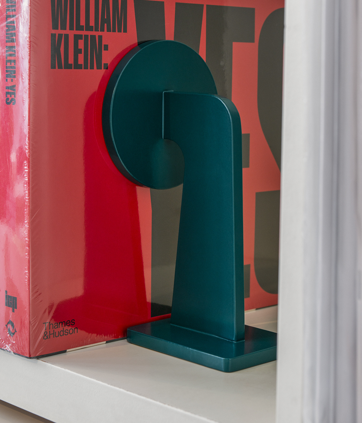 Massproductions BUFFER Buchstütze in tiefem Türkiston, aus pulverbeschichtetem Metall gefertigt, dekorativ mit aufgestellten Büchern inszeniert – elegantes und funktionales Accessoire für Regal oder Tisch

