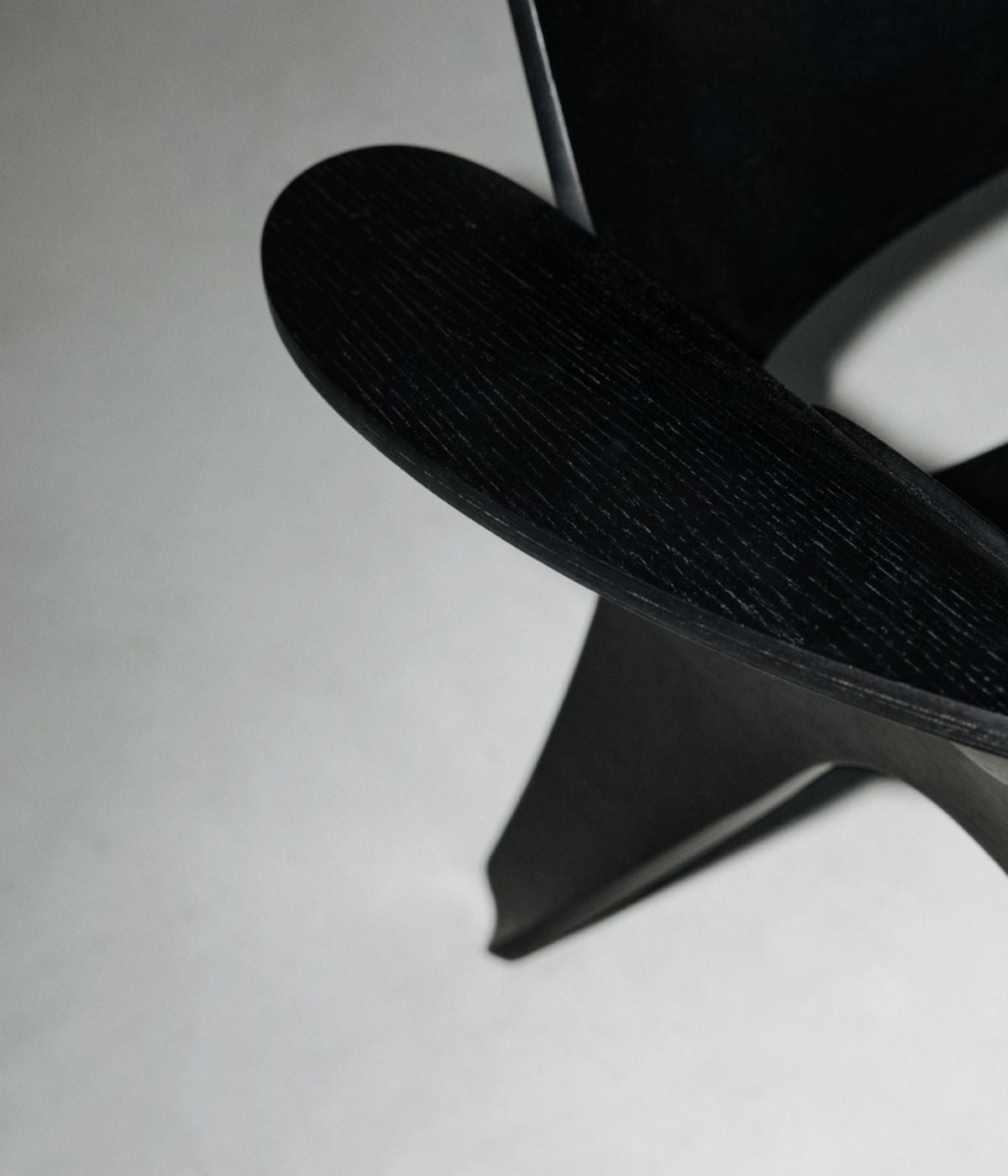 Nahaufnahme des schwarzen Rose Sessels von Massproductions. Die feine Struktur des Stoffes und die klaren Linien des Sessels kommen in dieser Detailaufnahme besonders gut zur Geltung, wodurch das hochwertige Design und die minimalistische Ästhetik hervorgehoben werden.