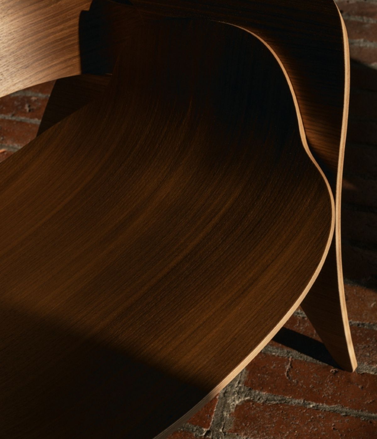 Rose Sessel von Massproductions, von oben aufgenommen mit Schatten im Raum. Das elegante Design des Sessels wird durch das sanfte Licht und die Schattenwirkung im Raum hervorgehoben, was dem Möbelstück eine gemütliche, einladende Atmosphäre verleiht.