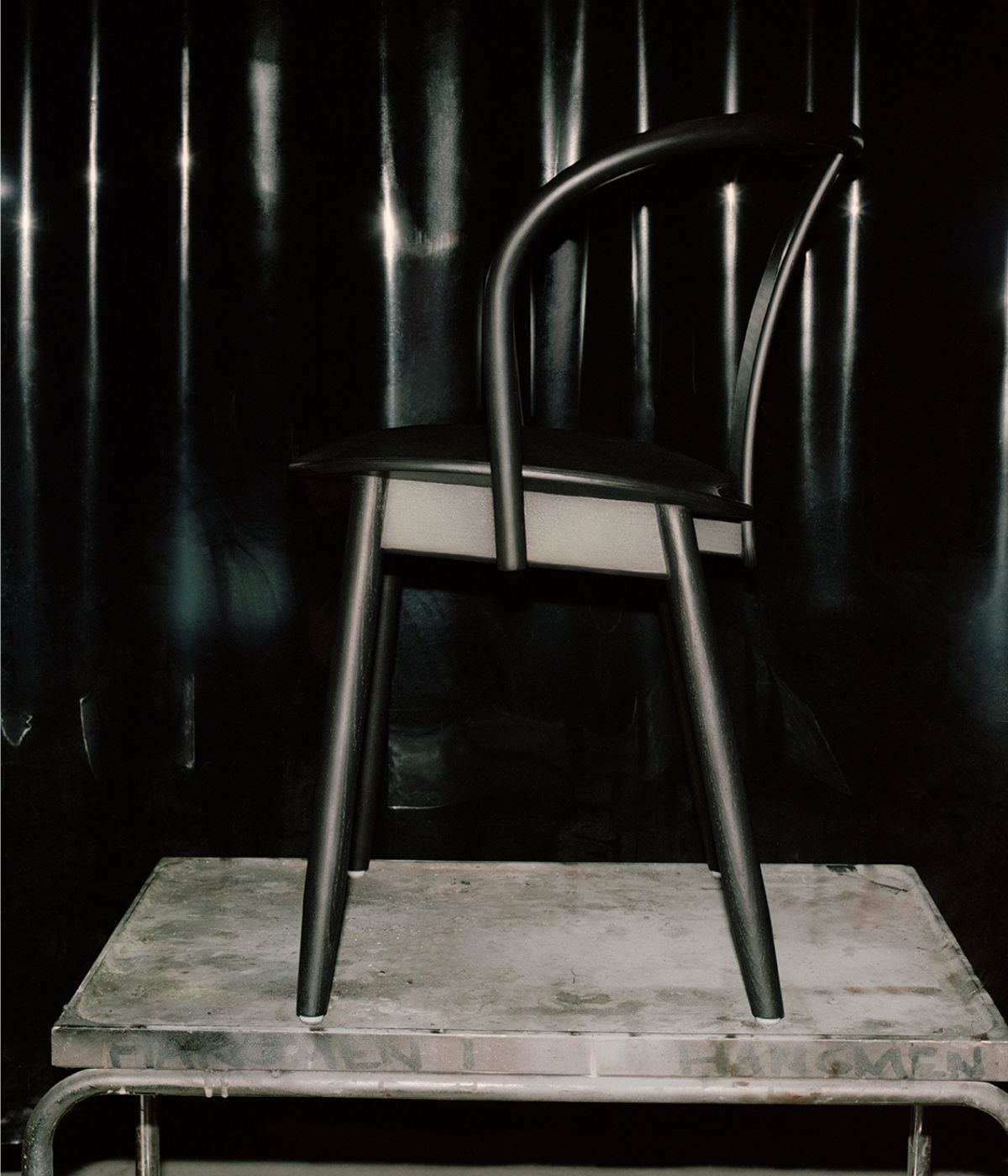 Icha Chair Schwarz auf einem Podest.